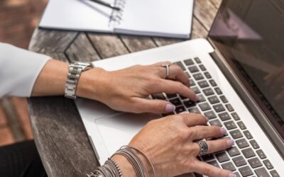 personne tapant sur un MacBook Pro sur une table en bois marron pendant la journée photo