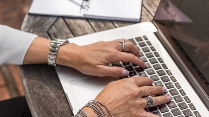 Business ado personne tapant sur un MacBook Pro sur une table en bois marron pendant la journée photo